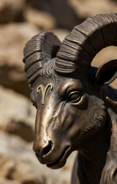 Escultura de bronce de una cabeza de carnero con el símbolo del signo de Aries.